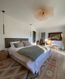 Dormitorio blanco con cama grande y alfombra en Chambre carpediem, en Orange