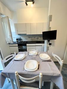 a kitchen with a table with white plates on it at A 5 minuti dal mare - Dolphin Beach House in Spotorno