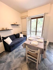 a living room with a table and a couch at A 5 minuti dal mare - Dolphin Beach House in Spotorno