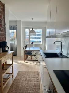 une cuisine blanche avec un évier et une table dans l'établissement Apartment Elviira, à Rovaniemi