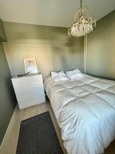 - une chambre avec un grand lit blanc et un lustre dans l'établissement Apartment Elviira, à Rovaniemi 10 autres photos
