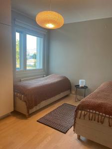 une chambre avec deux lits et une fenêtre dans l'établissement Apartment Elviira, à Rovaniemi
