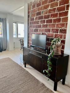 un salon avec une télévision sur un mur en briques dans l'établissement Apartment Elviira, à Rovaniemi