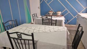 a dining room with two tables and three chairs at Epic Den Lodge in Phuthaditjhaba