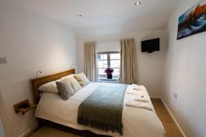 a bedroom with a large bed and a window at Southwell Holiday Cottage - Lavender Cottage in Southwell