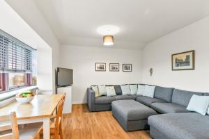 uma sala de estar com um sofá e uma mesa em Aspen Apartment em Helensburgh