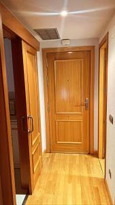 a hallway with a wooden door in a room at Airport Madrid suites apartments Belfast 13 in Madrid
