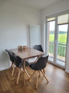 comedor con mesa de madera y sillas en Ferienwohnung Ruheoase Lüneburger Heide, en Natendorf