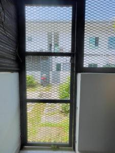 una ventana con vistas a un edificio a través de ella en Double Storey Sweet Home 12pax @ Puncak Alam, en Kuala Selangor
