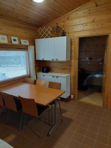 een keuken met een tafel en stoelen in een huisje bij Vierumäki in Vierumäki