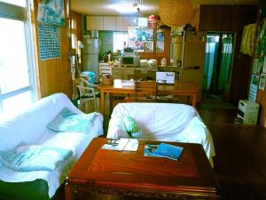 a living room with a couch and a table at Guest House Miyakojima in Miyako-jima