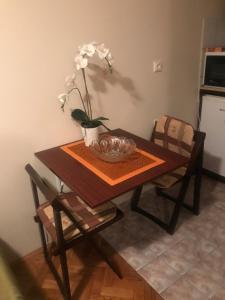 a dining room table with a bowl and flowers on it at Marija in Zlatibor