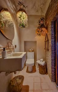 a bathroom with a sink and a toilet and chandeliers at Casa Amina in Chefchaouene