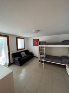 ein Wohnzimmer mit einem Sofa und einem Etagenbett in der Unterkunft La casa di Chicca in Noventa Padovana