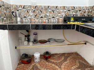 a kitchen with a counter with pots and pans at Habitación independiente Baño exterior in Armenia +10 photos