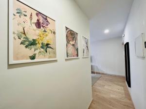 a hallway with paintings on the walls of a museum at Feeling Home Lope de Fenar in León +7 photos