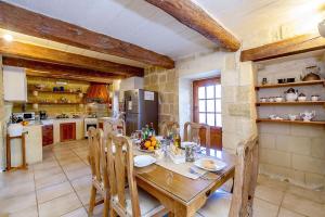 una cocina con mesa de madera con sillas y una cocina con en Ponderosa Holiday Home en Birbuba