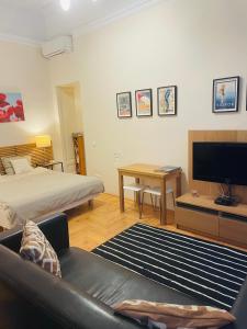Sala de estar con cama, sofá y TV en Studio B, en Budapest