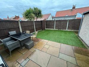 a small garden with a table and chairs on a patio at The Bungalow, Thornton-Cleveleys in Cleveleys