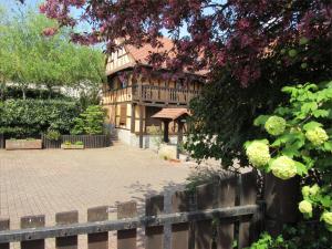 una casa grande con una valla delante en Gîte Le Vendangeur, en Donnenheim