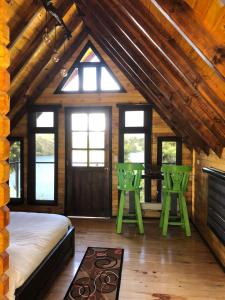 um quarto com uma cama e 2 bancos verdes em Playa Blanca - Glamping Bethél em Lago de Tota