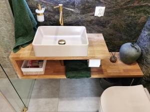 a bathroom with a white sink and a toilet at HEARTH HILL VIEW APARTMENT in Ustroń