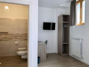 a bathroom with a toilet and a tv on the wall at RELSTAY - Amendola in Milan