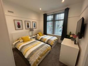 a bedroom with two beds and a window at The Bungalow, Thornton-Cleveleys in Cleveleys