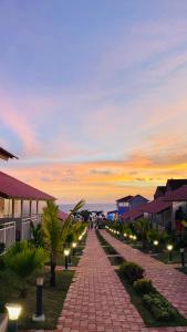 a brick road with street lights at sunset at Maargit Beach Resort in Mandrem