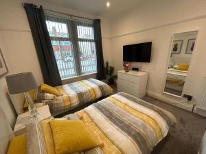 a bedroom with two beds and a television in it at The Bungalow, Thornton-Cleveleys in Cleveleys