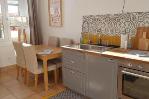 a kitchen with a table and a sink and a counter at Superbe 2 pièces avec grande terrasse, classé *** in Marseille