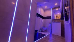 #1 TGHA Luxury Studio Apartment in Athlone في آثلون: حمام مع مرحاض واضاءة أرجوانية