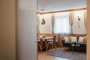 a living room with a couch and a table at Klimahaus Dep. La Fradora in San Cassiano