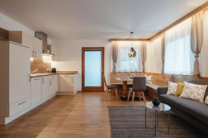 Una cocina y una sala de estar con un sofá y una mesa. en Klimahaus Dep. La Fradora, en San Cassiano 18 fotos más