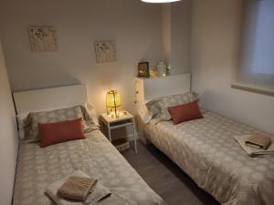 - une chambre avec deux lits et une table avec une lampe dans l'établissement Alazán Jerez II-Parking gratis-wifi-Netflix, à Jerez de la Frontera