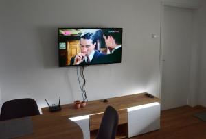 a flat screen tv hanging on a wall at Apatin apartman in Apatin