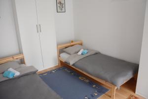 a bedroom with two beds and a rug at Apatin apartman in Apatin