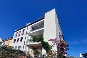 um edifício branco com flores em frente em Giuliana's House em Desenzano del Garda