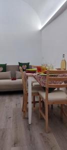 a dining room with a table and a couch at Lithos house pt 1p e 2p in Monopoli