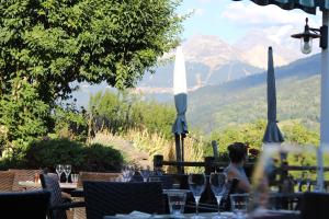 Eine Frau, die an einem Tisch mit Weingläsern sitzt. in der Unterkunft Auberge de Cassiel in La Côte-dʼAime