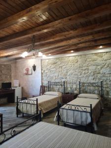 2 Betten in einem Zimmer mit einer Steinmauer in der Unterkunft Villa Russo in Caltanissetta