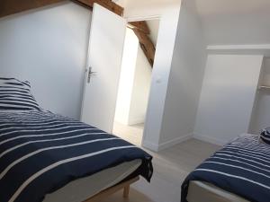 1 dormitorio con 2 camas con sábanas azules y blancas en grand gîte terrasse vue Loire et château d'Ancenis, en Ancenis