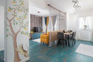 a living room with a tree and a dining room at Talida's apartment colorful and brightnes in Oradea