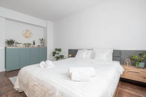 a bedroom with a large white bed with towels on it at Talida's apartment colorful and brightnes in Oradea