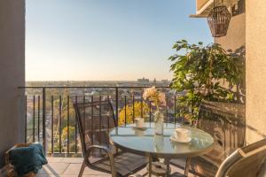 a table and chairs on a balcony with a view at Talida's apartment colorful and brightnes in Oradea