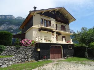 a house with a balcony on top of a stone wall at Au pied du Pertuiset in Drumettaz-Clarafond