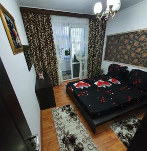 a bedroom with a black bed and a window at SWEET HOME & LiLiANA in Tecuci