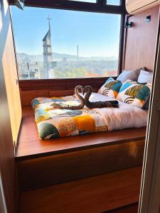 een stoel bij het raam in een boot met zwanen erop bij Eagle's Nest Short Stay in Baia Mare
