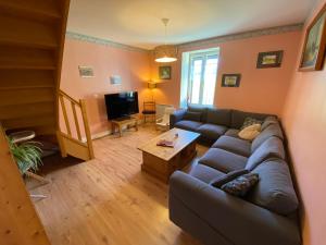 a living room with a couch and a tv at La grande marmite du lac de Vouglans in Pont-de-Poitte