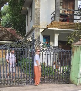 a woman standing in front of a iron fence at ABRU'S HOLIDAYS for Foreign Travelers in Alleppey